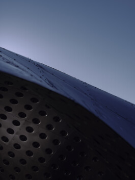 Detail Blechkante, reduzierte Inszenierung, dünne Edelstahllage und subtile Reflexionen entlang der Krümmung. Produkt-Fotografie