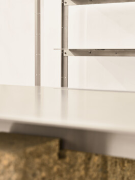 Makroaufnahme: Oberflächenstruktur der Stein-Edelstahl-Verbindung am Ausstellungstisch. Produkt-Fotografie