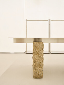 Nahaufnahme: Kante des Tisches mit sichtbarer Steinstruktur und metallischer Oberfläche. Produkt-Fotografie