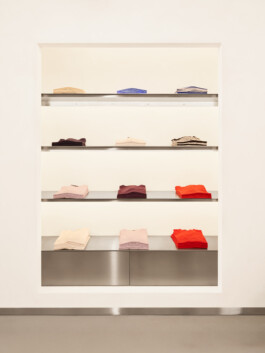 Totale: Display-Regal mit Kleidung — Blick auf modulare Präsentation und helle Farbpalette. Produkt-Fotografie