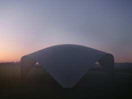 Airfoil Prototyp Aachen bei Morgendämmerung, weite Totale, inszenierte Komposition, Gegenlicht betont die doppelt gekrümmte Edelstahlfläche. Produkt-Fotografie